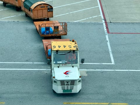Tow tractor pulling air cargo containers on an airport apron